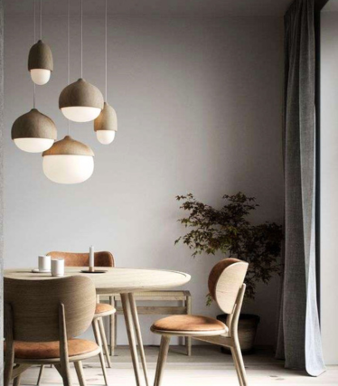 Natural wood pendant lights above a modern dining table in a bright Scandinavian interior.
