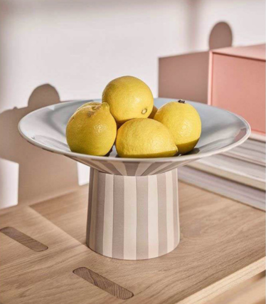 OY OY Living bowl with lemons on a stylish wooden table in soft pastel tones.
