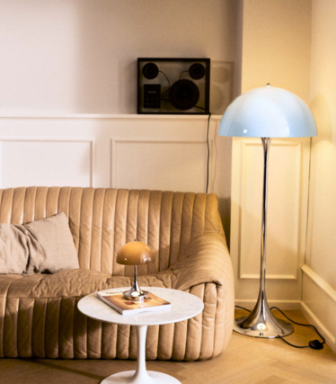 Louis Poulsen Panthella floor lamp and table lamp in a warm living room with a leather sofa